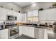 Modern kitchen featuring stainless steel appliances, white cabinets, and black countertops at 130 Twin Towers Ave, Las Vegas, NV 89123