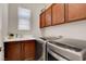 Laundry room with modern washer and dryer and wood cabinets at 130 Twin Towers Ave, Las Vegas, NV 89123