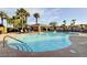 Large community pool surrounded by palm trees and lounge chairs for relaxing on a sunny day at 130 Twin Towers Ave, Las Vegas, NV 89123