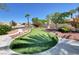 Scenic putting green featuring lush artificial turf, mature trees, and a professionally landscaped area, perfect for outdoor recreation at 130 Twin Towers Ave, Las Vegas, NV 89123