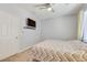 Cozy bedroom features a flat-screen TV, ceiling fan, and natural light at 1316 Oak Village Ave, Las Vegas, NV 89183