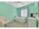 Bright bedroom featuring mint-green walls, ceiling fan, and a twin bed at 1316 Oak Village Ave, Las Vegas, NV 89183
