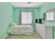 Bright bedroom featuring mint-green walls, ceiling fan, and a twin bed at 1316 Oak Village Ave, Las Vegas, NV 89183