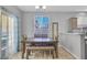Bright dining room with wood floors, dining table, bench seating, and sliding glass door to the outside at 1316 Oak Village Ave, Las Vegas, NV 89183