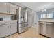 Open kitchen features stainless appliances, light gray cabinets, and overlooks the dining area at 1316 Oak Village Ave, Las Vegas, NV 89183