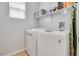 Functional laundry room with modern washer and dryer units and shelving at 1316 Oak Village Ave, Las Vegas, NV 89183