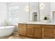 Elegant bathroom featuring a double vanity, a soaking tub and modern light fixtures at 1343 Panini Dr, Henderson, NV 89052