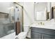 Modern bathroom with gray vanity, white marble countertop, and glass enclosed shower with gold hardware at 1343 Panini Dr, Henderson, NV 89052