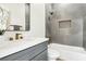 Modern bathroom with gray vanity, white marble countertop, gray tiled shower with gold hardware at 1343 Panini Dr, Henderson, NV 89052
