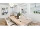 Bright dining area with a large wooden table, seating for eight, and contemporary light fixtures at 1343 Panini Dr, Henderson, NV 89052