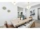 Elegant dining room features a large table, chairs, a modern light fixture, and wood flooring at 1343 Panini Dr, Henderson, NV 89052