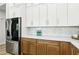 Bright kitchen features stainless steel refrigerator and wood-look base cabinets and white upper cabinets at 1343 Panini Dr, Henderson, NV 89052