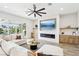 Relaxing living room boasts a white sectional, fireplace, large screen TV, and views of the pool at 1343 Panini Dr, Henderson, NV 89052