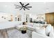 Spacious living room with white sectional sofa, ceiling fan, and open view to the modern kitchen at 1343 Panini Dr, Henderson, NV 89052