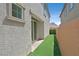 Long backyard with artificial turf, privacy walls, a view of the mountains, and a sliding glass door at 1388 Graphite Ave, Henderson, NV 89002