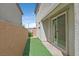 Narrow backyard with artificial turf, privacy wall and sliding glass door into home at 1388 Graphite Ave, Henderson, NV 89002