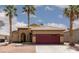 Charming single-story home with desert landscaping, palm trees and a red two car garage door at 1723 Anchor Dr, North Las Vegas, NV 89032