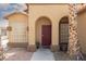 Inviting home entrance with an arched doorway, decorative windows, and desert-friendly landscaping at 1723 Anchor Dr, North Las Vegas, NV 89032