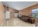 Spacious living room with high ceilings, cozy sofa, and wood-look tile flooring at 1723 Anchor Dr, North Las Vegas, NV 89032