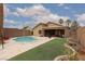 Backyard featuring a refreshing pool, well-manicured grass, and a covered patio for relaxation at 1723 Anchor Dr, North Las Vegas, NV 89032