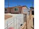 Home featuring a decorative fence, brick wall, and driveway extending to the backyard at 1972 H St, Las Vegas, NV 89106