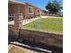 Home's front yard with grass, brick wall, and decorative iron fencing at 1972 H St, Las Vegas, NV 89106