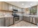 Modern kitchen with stainless steel appliances, tile backsplash, and natural light from the window at 2486 Sabado St, Las Vegas, NV 89121