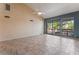 Spacious living room with tile flooring, vaulted ceiling, and sliding door access to the patio at 2486 Sabado St, Las Vegas, NV 89121
