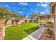 Beautiful backyard featuring a covered patio, green artificial turf, and well-maintained landscaping for outdoor enjoyment at 2561 Pyramid Pines Dr, Henderson, NV 89052
