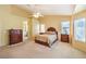 Spacious bedroom with a ceiling fan, large windows, and an ensuite bathroom with a soaking tub at 2561 Pyramid Pines Dr, Henderson, NV 89052
