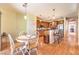 Open dining space featuring wood floors, pendant lighting, access to the kitchen, and backyard views at 2561 Pyramid Pines Dr, Henderson, NV 89052
