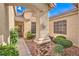 Charming stone-accented porch entrance with desert landscaping, and a sun-shaped decor piece at 2561 Pyramid Pines Dr, Henderson, NV 89052