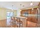 Spacious kitchen with a breakfast bar, wooden cabinets, and a stainless steel refrigerator at 2561 Pyramid Pines Dr, Henderson, NV 89052