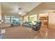 Spacious living room with natural lighting, carpeted floors, and open access to the kitchen at 2561 Pyramid Pines Dr, Henderson, NV 89052