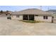 Rear exterior of home featuring a covered patio, desert landscape, and ample space for outdoor living at 2571 N David St, Pahrump, NV 89060