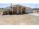 Inviting single-story home with covered porch, two-car garage, and desert surroundings at 2571 N David St, Pahrump, NV 89060