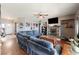 Spacious living room with hardwood floors, a ceiling fan, and a cozy fireplace, perfect for relaxation at 2571 N David St, Pahrump, NV 89060