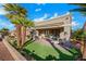 The backyard patio with artificial turf and desert landscaping and a partial view of the home's exterior at 2621 Spalding Dr, Las Vegas, NV 89134