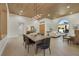 Open concept dining room with modern light fixture and views into the living room and backyard at 2621 Spalding Dr, Las Vegas, NV 89134