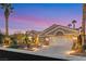 Inviting single-story home with beautiful landscaping, a well-manicured lawn, and a two-car garage at 2621 Spalding Dr, Las Vegas, NV 89134