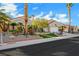 Attractive single-story home featuring lush desert landscaping, mature palm trees, and a two-car garage at 2621 Spalding Dr, Las Vegas, NV 89134