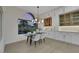 Charming dining area adjacent to a well-appointed kitchen, highlighted by a modern chandelier and a large window with scenic views at 2621 Spalding Dr, Las Vegas, NV 89134