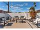 Outdoor seating area in a backyard featuring comfortable seating, mature plantings, and a white brick wall at 2909 Gilmary Ave, Las Vegas, NV 89102