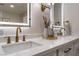 Bathroom vanity with double sinks, lit mirrors, and gold fixtures, complemented by stylish decor at 2909 Gilmary Ave, Las Vegas, NV 89102