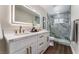 Modern bathroom with a dual sink vanity, illuminated mirror, and glass enclosed shower with designer tile at 2909 Gilmary Ave, Las Vegas, NV 89102