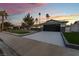 Charming single-story home featuring a putting green and modern garage door at dusk at 2909 Gilmary Ave, Las Vegas, NV 89102