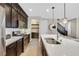 Gourmet kitchen featuring dark wood cabinets, stainless steel appliances, a spacious island, and modern pendant lighting at 3179 Mura Del Prato Ave, Henderson, NV 89044