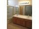 Bathroom features a double sink vanity, framed mirror, and shower with gold trim at 3208 Regal Swan Pl # 3, North Las Vegas, NV 89084