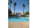 Beautiful community pool featuring mature palm trees and clear blue water at 3208 Regal Swan Pl # 3, North Las Vegas, NV 89084