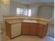 Kitchen view showcasing a double basin sink, wood cabinets, and a white dishwasher at 3208 Regal Swan Pl # 3, North Las Vegas, NV 89084